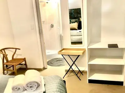 a bedroom with a bed and a mirror and a chair at Paarl Views in Paarl