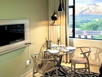 a dining room with a table and chairs and a window at Paarl Views in Paarl