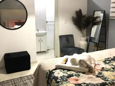 a bedroom with a bed and a mirror and a chair at Paarl Views in Paarl