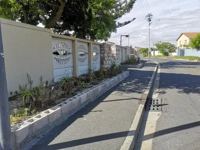 a fence with eyes painted on it next to a street at Coastal Cozy 1 in Cape Town
