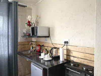a kitchen with a counter with a microwave on the wall at Coastal Cozy 1 in Cape Town