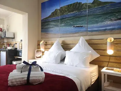 a bedroom with a bed with a painting on the wall at Coastal Cozy 1 in Cape Town