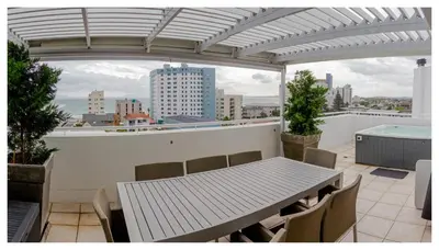 a table and chairs on a balcony with a view of a city at St Clouds Strand in Strand