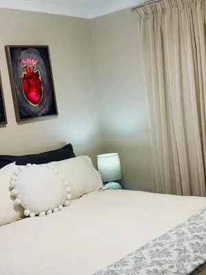 a bedroom with a white bed and a window at Modern charm in Pinelands in Cape Town