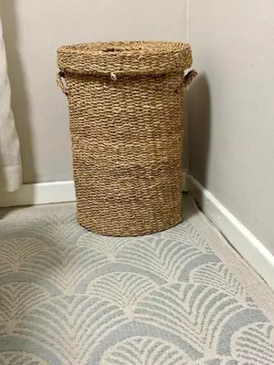 a wicker trash can sitting next to a wall at Modern charm in Pinelands in Cape Town