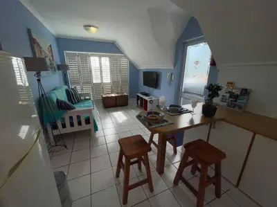 a kitchen with a table and chairs in a room at De Blauwvoet - Flamingo Apartment in Cape Town