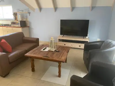 a living room with a coffee table and a flat screen tv at De Blauwvoet - Meerkat (Sunset Beach) in Cape Town