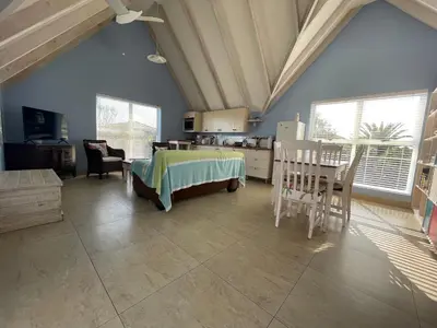 a bedroom with a bed and a table and chairs at De Blauwvoet - Dolfyn (Sunset Beach) in Cape Town