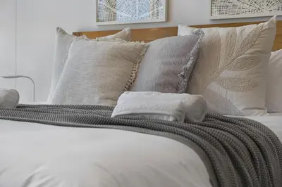 a bed with white sheets and pillows at Welgelegen 608 in Strand
