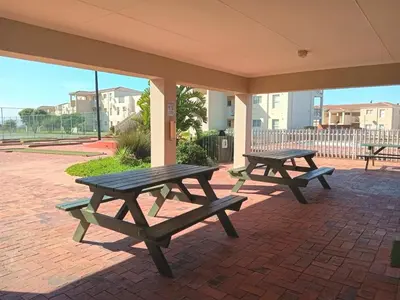 two picnic tables sitting on a brick patio at 241 hermanus beach club in Hermanus
