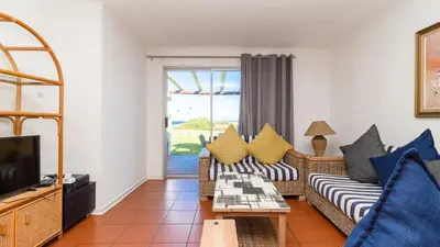 a living room with a couch and a tv at 241 hermanus beach club in Hermanus