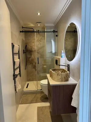 a bathroom with a sink and a toilet and a shower at Dolphin Beach beachfront apartment, 3 bedroom-6 persons in Cape Town