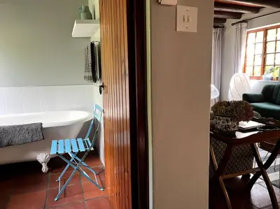 a room with a tub and a chair in a room at Comfy Greyton Cottage for Four in Greyton