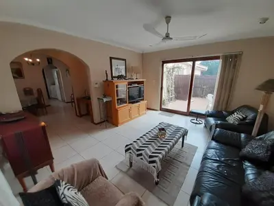a living room with a couch and a table at Blouberg Cosy 2 bedroom house in Cape Town