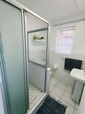 a bathroom with a glass shower and a sink at NoulAnouk's Corner - Peaceful Studio in Cape Town