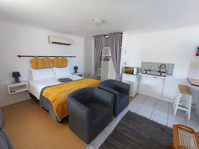 a hotel room with a bed and a chair at NoulAnouk's Corner - Peaceful Studio in Cape Town