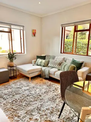 a living room with a couch and two windows at Petit Casa Central Stellenbosch in Stellenbosch