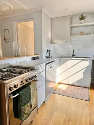a kitchen with white counters and a stove top oven at Petit Casa Central Stellenbosch in Stellenbosch