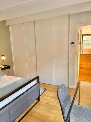 a bedroom with a bed and a chair at Petit Casa Central Stellenbosch in Stellenbosch