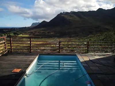 a swimming pool with a view of a mountain at Witteklip self-catering farm in Kleinmond