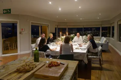 a group of people sitting at a table eating at Fijnbos Private Manor in Gordonʼs Bay