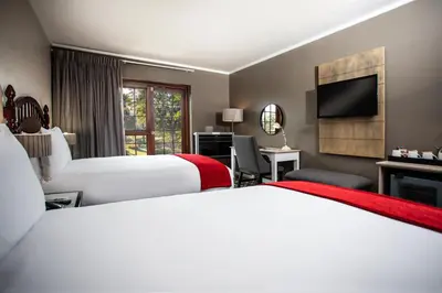 a hotel room with two beds and a flat screen tv at The Caledon Hotel and Spa in Caledon