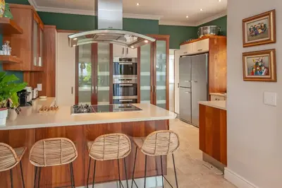 a kitchen with a counter and stools in it at Wild Waters at Kraal Rock on the cliffs in Hermanus in Hermanus