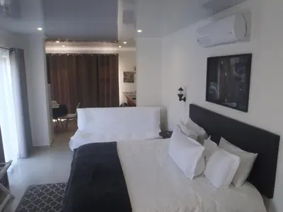 a bedroom with two beds with white sheets and pillows at Mi Amor Accommodation in Brackenfell