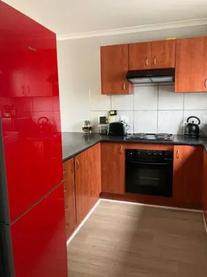 a kitchen with red cabinets and a red refrigerator at Mini Suits in Cape Town
