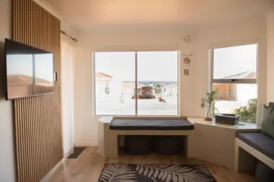 a room with a window and a desk with a window seat at Hermanus Sea Breeze in Hermanus
