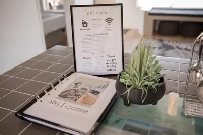 a book sitting on a counter next to a potted plant at Hermanus Sea Breeze in Hermanus