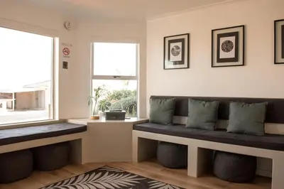a living room with a bench and a window at Hermanus Sea Breeze in Hermanus