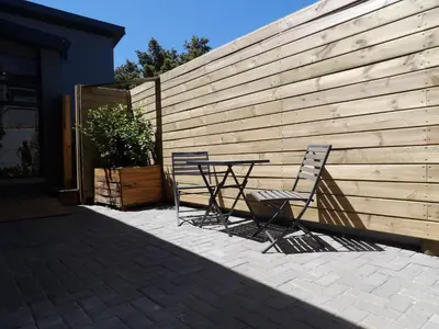 two chairs and a table in front of a fence at Maîté Iphupho in Somerset West