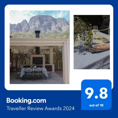 a picture of a patio with a table and a mountain at Three Streams Cottages in Franschhoek