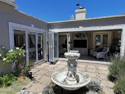 a patio with a fountain in front of a house at Ocean and mountain breeze in Hermanus