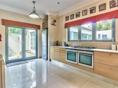 a large kitchen with wooden cabinets and windows at Villa Jesdene in Cape Town