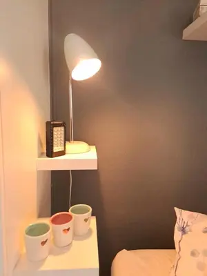 a lamp on a shelf with three cups and a phone at Cosy and Central Family Home in Cape Town