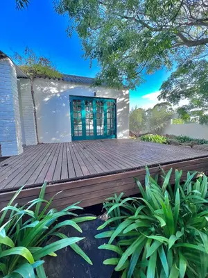 a wooden deck in front of a house with plants at Tollbosch in Somerset West