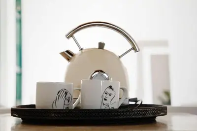 a tray with three mugs with faces on them at Tollbosch in Somerset West