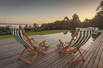 two chairs sitting on a deck next to a pool at Southwinds Estate in Hermanus