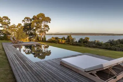 a swimming pool on a deck next to a lake at Southwinds Estate in Hermanus