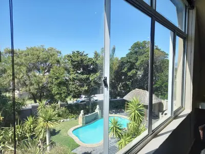 a view of a swimming pool from a window at Mandalay Beach Guest House in Bloubergstrand