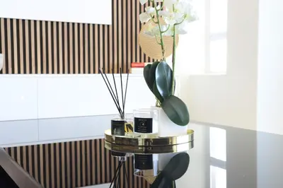 a table with a vase with flowers in it at Portico 1006 Beachfront Apartment with Panoramic Views in Cape Town