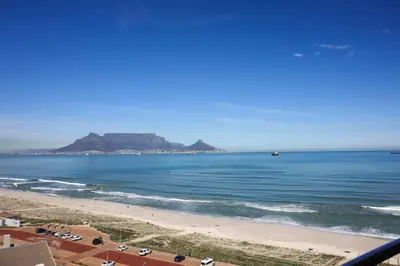 a view of a beach with a mountain in the background at Portico 1006 Beachfront Apartment with Panoramic Views in Cape Town