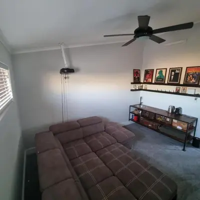 a living room with a couch and a ceiling fan at Kwikstertjie in Hermanus
