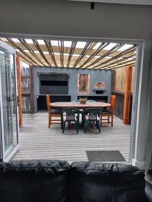 a screened in porch with a table and chairs at Kwikstertjie in Hermanus
