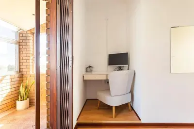 a room with a desk with a chair and a computer at Innie Baai Beach House in Cape Town