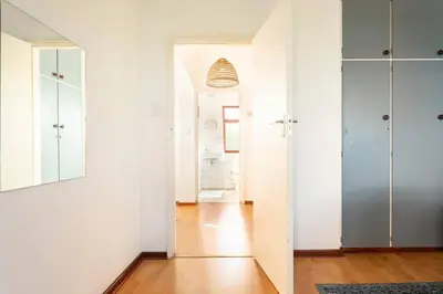 a hallway with white walls and a mirror at Innie Baai Beach House in Cape Town