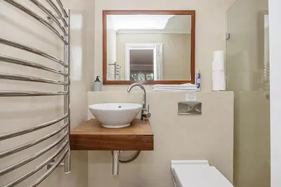 a bathroom with a bowl sink and a mirror at The Island Beach Villa in Cape Town