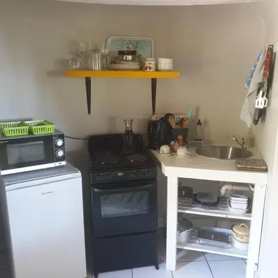 a small kitchen with a stove and a sink at Irma's farmstay at the Nuy Valley Guesthouse in Nuy